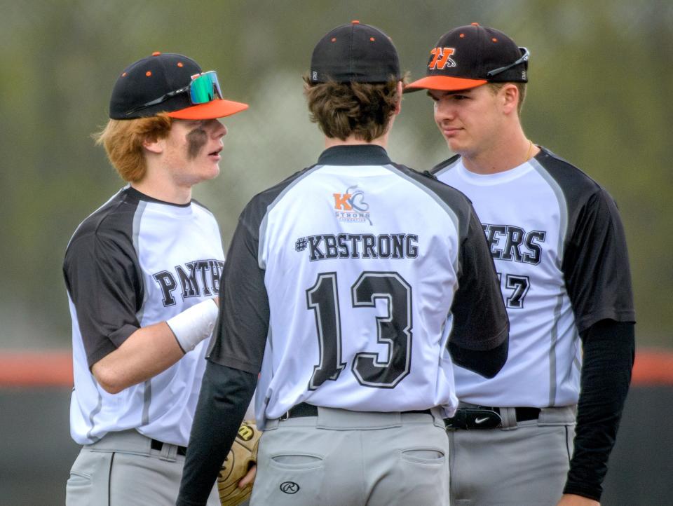 Washington's Easton Harris, left, chats with teammates Gus Lucas, right, and Tyler Bishop during a recent game against Springfield at Washington Community High School.