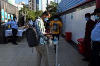 A student sanitises his hands as he arrives at an examination centre for Joint Entrance Examination (JEE ) Main-2020, one of the most competitive entrance exams for entry to top national engineering colleges, in Noida on September 1, 2020. (Photo by PRAKASH SINGH/AFP via Getty Images)