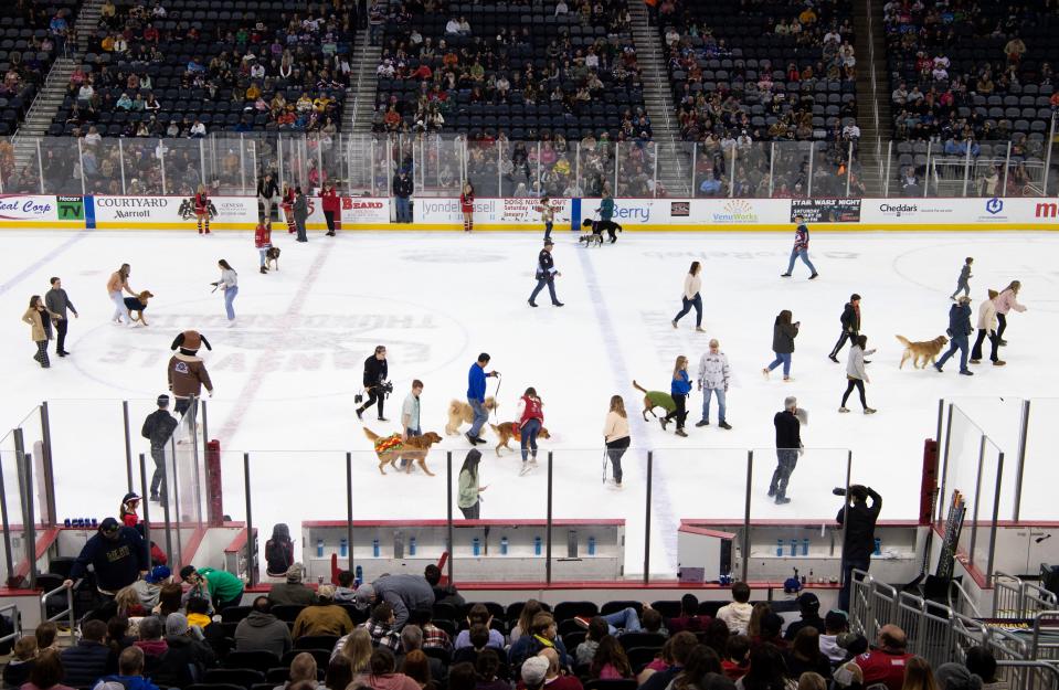 Dogs and their people gather on the ice for the large dogs race during the Thunderbolts' "Dogs Night Out" at Ford Center Saturday night, Jan. 7, 2023.