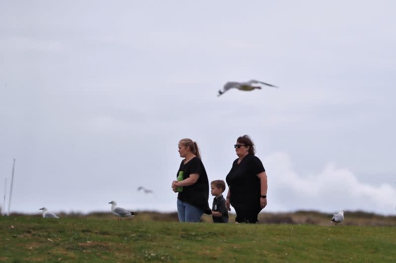 Relatives of the volcano eruption victims walk back from the memorial at the harbour in Whakatane, New Zealand