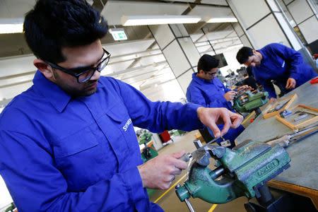 FILE PHOTO: Refugees show their skills in metal processing works during a media tour at a workshop for refugees organized by German industrial group Siemens in Berlin, Germany, April 21, 2016. REUTERS/Fabrizio Bensch/File Photo