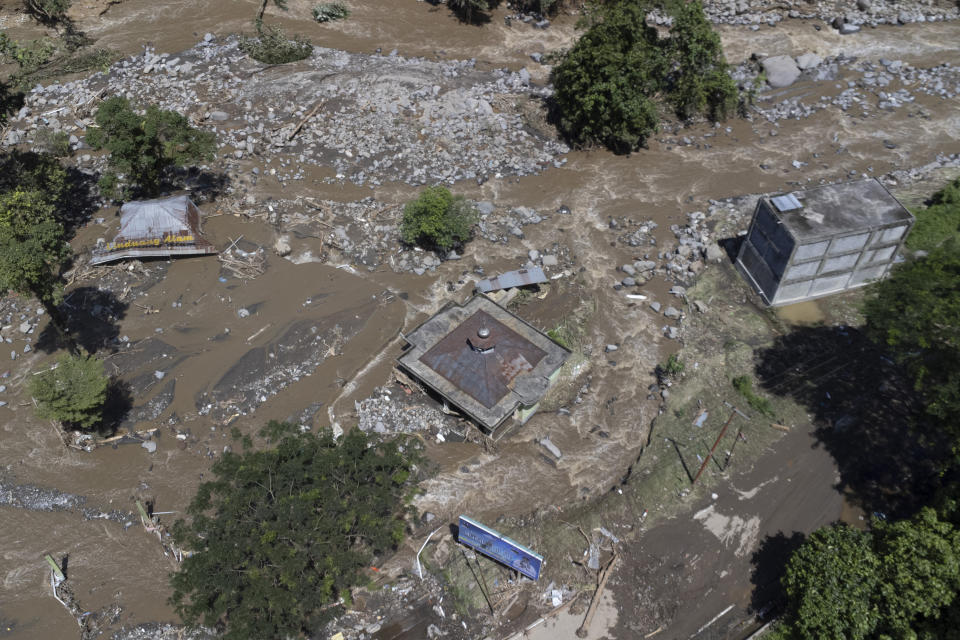 This drone shot shows buildings damaged by a flash flood in Tanah Datar, West Sumatra, Indonesia, Sunday, May 12, 2024. Heavy rains and torrents of cold lava and mud flowing down a volcano's slopes on Indonesia's Sumatra island triggered flash floods that killed and injured a number of people, officials said Sunday. (AP Photo/Sutan Malik Kayo)
