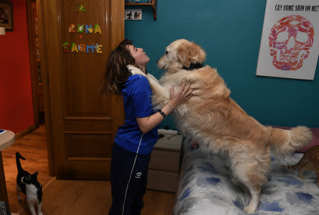 Carmen Lopez Garcia, Spain's first blind female surfer who is to participate in the ISA World Adaptive Surfing Championship, plays with her dog at her apartment in Oviedo, Spain, December 5, 2018. REUTERS/Eloy Alonso