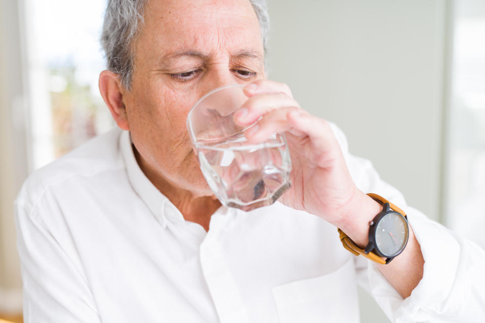 Man drinking a fresh glass of water at home. (Getty Images)