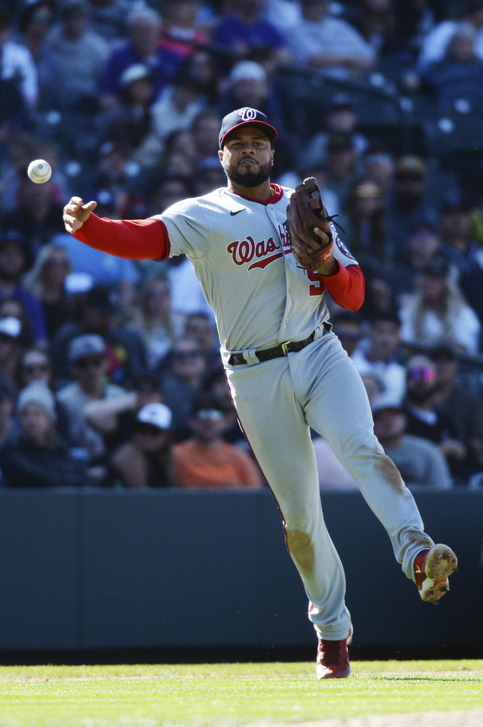 Washington Nationals third baseman Jeimer Candelario throws out a runner at first base in the eighth inning of a baseball game Sunday, April 9, 2023, in Denver. (AP Photo/Geneva Heffernan)