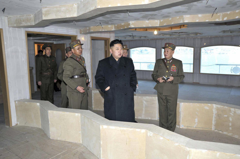 This undated photo released on March 25, 2013, North Korean leader Kim Jong-Un (C) inspecting a restaurant boat Taedonggang being laid down by the Korean People's Army at an undisclosed location in North Korea.