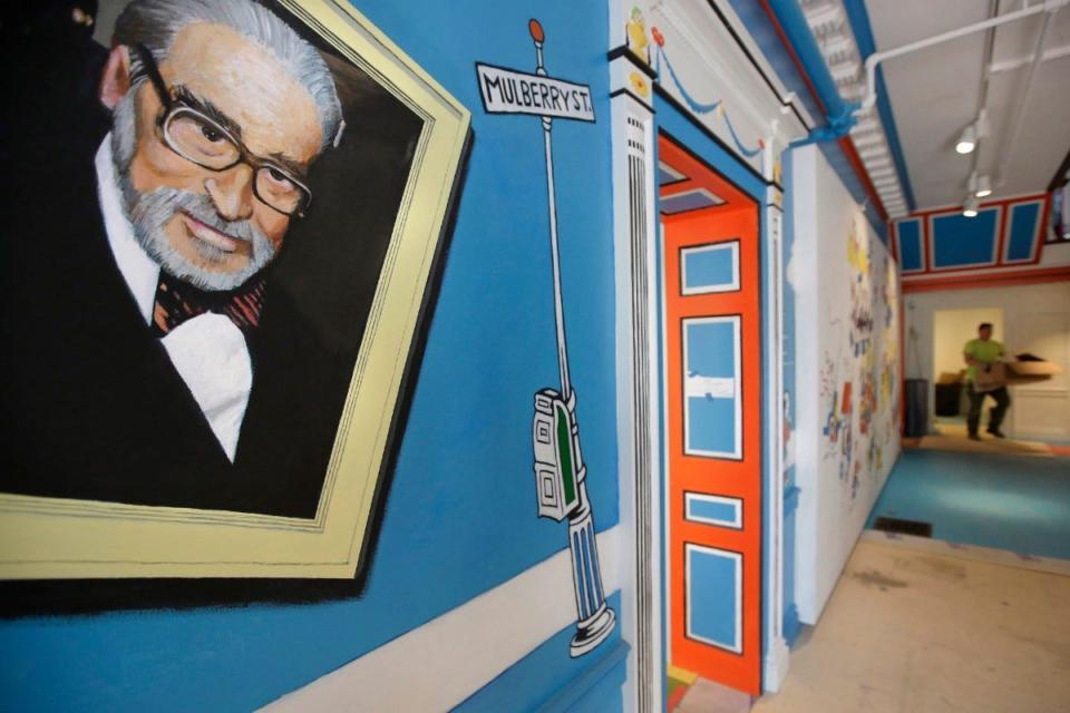 In this May 4, 2017, photo, a mural that features Theodor Seuss Geisel, left, also known by his pen name Dr. Seuss, covers part of a wall near an entrance at The Amazing World of Dr. Seuss Museum in Springfield, Massachusetts.