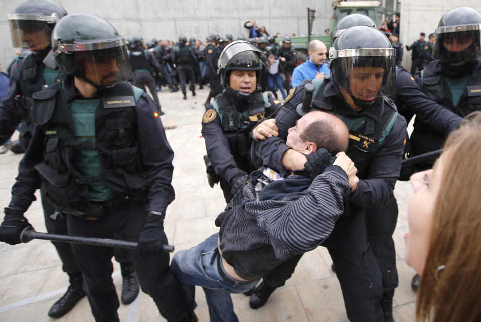 <p>Spanish Guardia Civil guards drag a man outside a polling station in Sant Julia de Ramis, where Catalan president was supposed to vote, on Oct. 1, 2017, on the day of a referendum on independence for Catalonia banned by Madrid. (Photo: Fabio Bucciarelli/AFP/Getty Images) </p>