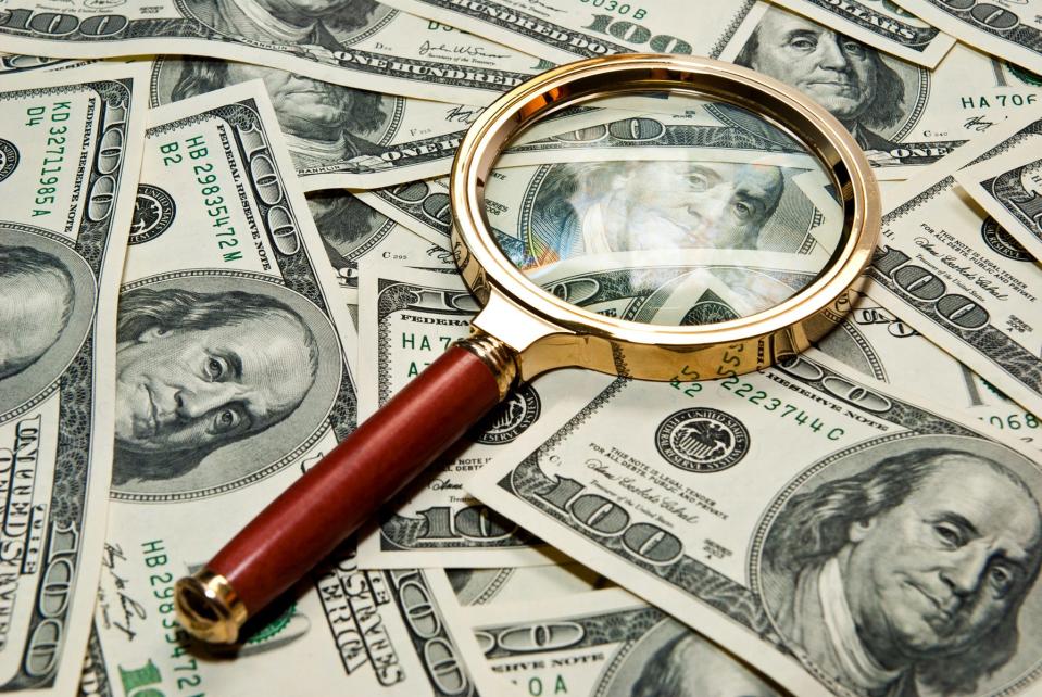 magnifying glass on a dollar background