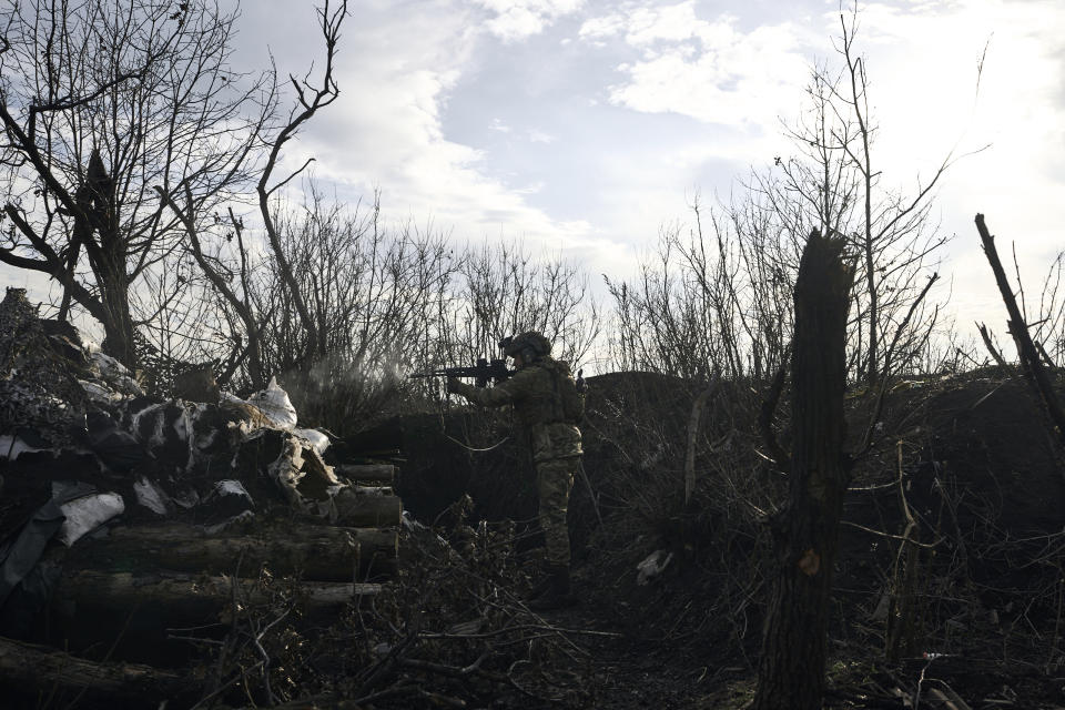 A Ukrainian soldier fires towards Russian positions at a frontline near Maryinka, Donetsk region, Ukraine, Friday, Dec. 23, 2022. (AP Photo/Libkos)