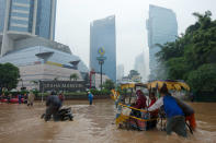 People wade through floodwaters in Jakarta's central business district on January 17, 2013 in Jakarta, Indonesia. Thousands of Indonesians were displaced and the capital was covered in many key areas in over a meter of water after days of heavy rain. (Photo by Ed Wray/Getty Images)