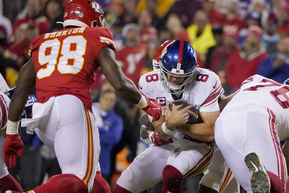 New York Giants quarterback Daniel Jones (8) protects the ball as Kansas City Chiefs defensive tackle Tershawn Wharton (98) defends during the first half of an NFL football game Monday, Nov. 1, 2021, in Kansas City, Mo. (AP Photo/Ed Zurga)