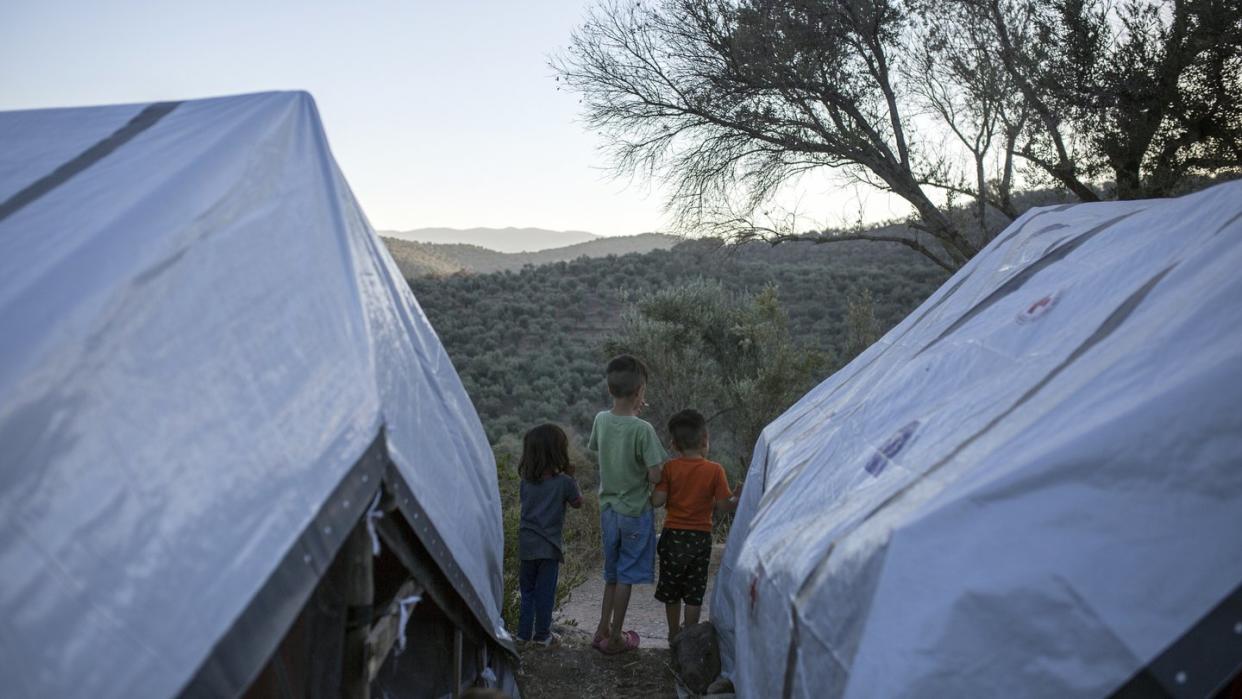 Kinder stehen zwischen Zelten in einem provisorischen Flüchtlingslager auf Lesbos.