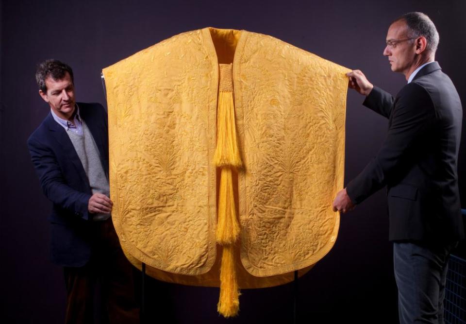 Creators Simon Peers (left) and Nick Godley arrange their Golden Spider Silk Cape, made from the silk spun by female golden orb weaver spiders