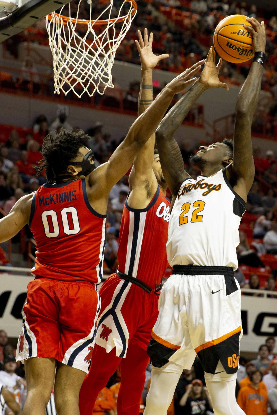 Mississippi's Jayveous McKinnis, left, and Myles Burns, center, guard against Oklahoma State's Kalib Boone (22) in the first half of an NCAA college basketball game in Stillwater, Okla., Saturday, Jan. 28, 2023. (AP Photo/Mitch Alcala)