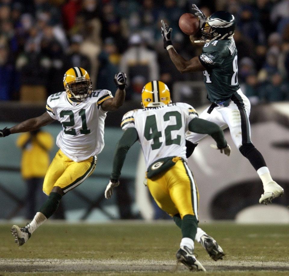 Philadelphia Eagles receiver Freddie Mitchell snares a pass for first down when it was fourth and 26 while being covered by Green Bay Packers Bhawoh Jue (21) and Darren Sharper late in the fourth quarter of their game Sunday, January 11, 2004 at Lincoln Financial Field in Philadelphia.