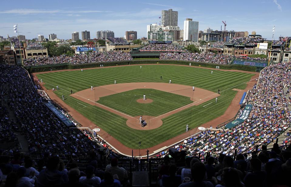 FILE - In this Aug. 4, 2013, file photo, the Los Angeles Dodgers play the Chicago Cubs at Wrigley Field in Chicago. Wrigley Field has been the site of so much heartbreak that some fans who spend their whole lives waiting for a winner ask their families, if they can pull it off, to sneak their ashes inside to be scattered in the friendly confines _ a final resting place to keep on waiting. But before years turned into decades and decades turned into a century without a World Series title, Wrigley Field was in first time and time again in changing the way we watch baseball and the experience for fans in ballparks around the country. The historic ballpark will celebrate it's 100th anniversary on April 23, 2014. (AP Photo/Kiichiro Sato, File)