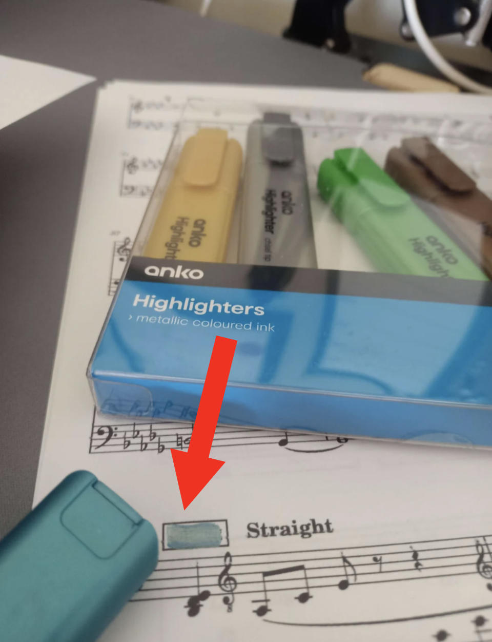 Four highlighters on sheet music, with a close-up of blue pack reading 'metallic coloured ink'