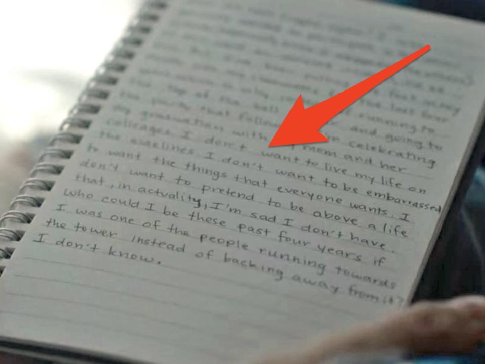 close-up shot of two hands holding a journal on a lap while writing in along for the ride