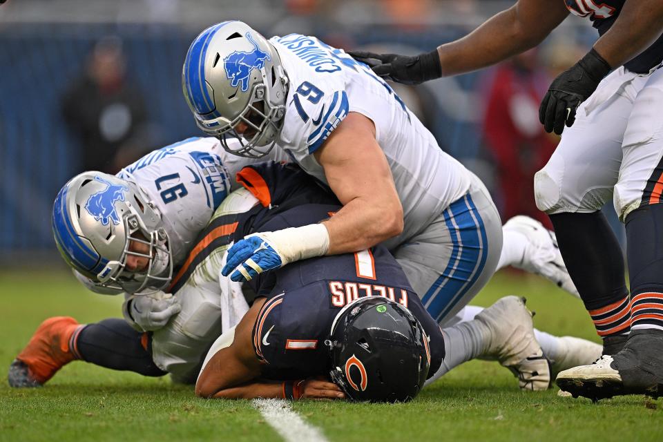 Lions defensive linemen Aidan Hutchinson (97) and John Cominsky sack Bears quarterback Justin Fields during the second quarter on Sunday, Dec. 10, 2023, in Chicago.