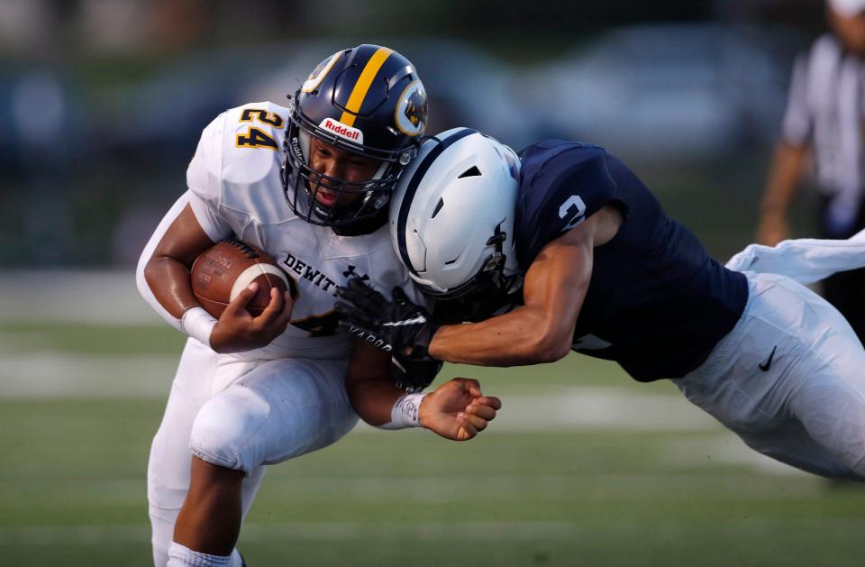 DeWitt's Rece Baker, left, is tackled by East Lansing's Evan Boyd, Friday, Sept. 16, 2022, in East Lansing, Mich. East Lansing won 36-30.