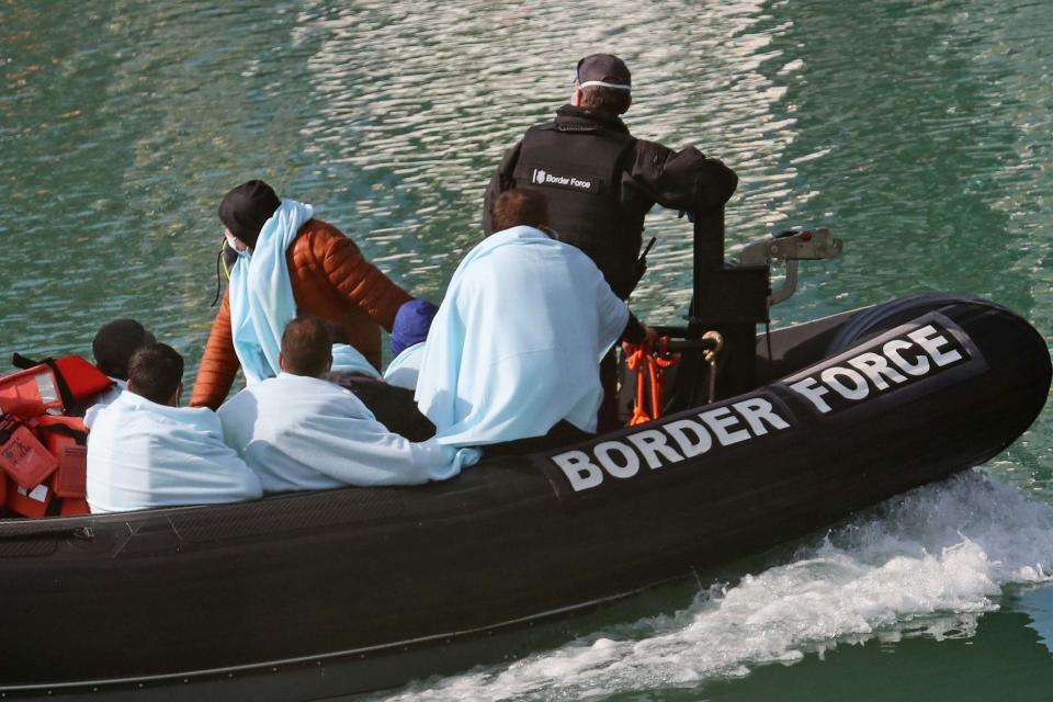 A group of people thought to be migrants being brought into Dover, Kent, by Border Force officers following a small boat incident in the Channel (PA)