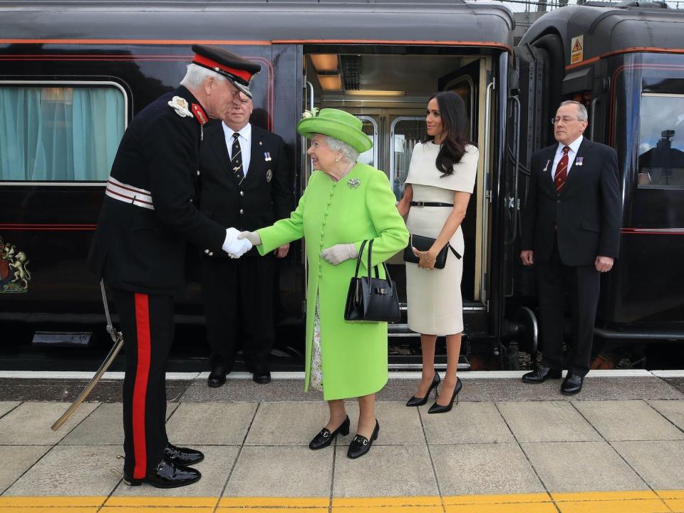 Queen Elizabeth II is greeted with Meghan Markle, Duchess of Sussex, as they arrive by Royal Train at Runcorn Station in Cheshire, England, in 2018.