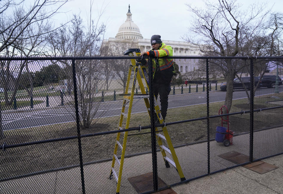 FILE - A worker completes construction of perimeter fence around the U.S. Capitol, Feb. 5, 2023, in Washington. The fencing was installed around the Capitol before the Tuesday evening State of the Union address. Biden on Tuesday night will stand before a joint session of Congress for the first time since voters in the midtem elections handed control of the House to Republicans. (AP Photo/Carolyn Kaster, File)