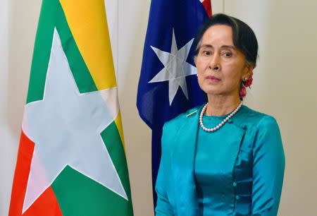 Myanmar's State Counsellor Aung San Suu Kyi stands next to national flags of Australia and Myanmar at Parliament House in Canberra, Australia, March 19, 2018. AAP/Mick Tsikas/via REUTERS