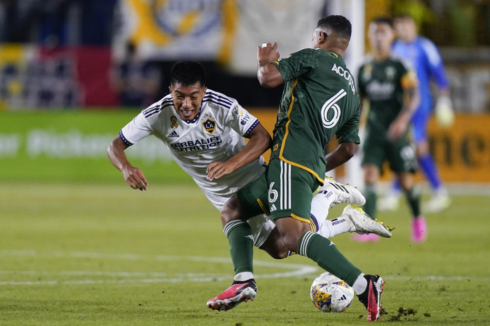 LA Galaxy midfielder Daniel Aguirre, left, collides with Portland Timbers midfielder Bryan Acosta during the second half of an MLS soccer match, Saturday, Sept. 30, 2023, in Carson, Calif. (AP Photo/Ryan Sun)
