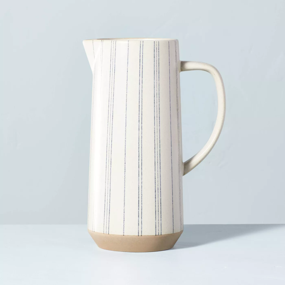 white and blue striped pitcher on light blue backdrop