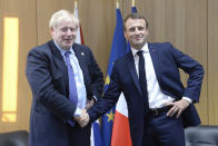 Britain's Prime Minister Boris Johnson poses as he shakes the hand of French President Emmanuel Macron, right, during a European Union leaders summit in Brussels, Belgium, Thursday Oct. 17, 2019. Britain and the European Union reached a new tentative Brexit deal on Thursday, hoping to finally escape the acrimony, divisions and frustration of their three-year negotiation. (Johanna Geron/Pool via AP)