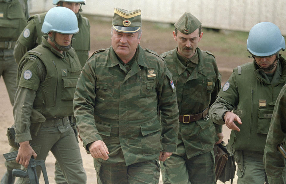 FILE - This is a April 12, 1993 file photo of Bosnian Serb army Gen. Ratko Mladic, second from left, accompanied by an aide, and French U.N. security troops arrive at a U.N. sponsored meeting at Sarajevo's airport. U.N. judges will on Tuesday, June 8, 2021 deliver their final ruling on the conviction of former Bosnian Serb army chief Ratko Mladic on charges of genocide, war crimes and crimes against humanity during Bosnia's 1992-95 ethnic carnage. (AP Photo/Michael Stravato, File)