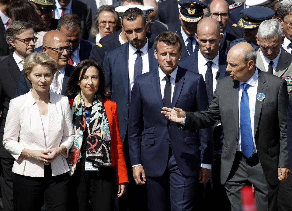 German Defense Minister Ursula von der Leyen, left, Spanish Defence Minister Margarita Robles, second left, French President Emmanuel Macron and Dassault Aviation Chairman and CEO Eric Trappier, right, visit the Paris Air Show in Le Bourget Airport near Paris, France, Monday June 17, 2019. (Yoan Valat/Pool via AP)