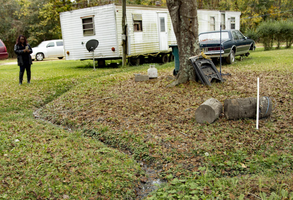 Environmental justice advocate Catherine Flowers examines an open sewer in the yard of a Lowndes County, Alabama, resident. Repeated exposure to raw sewage can lead to hookworm infections.&nbsp; (Photo: Anna Leah for HuffPost)