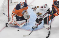 Edmonton Oilers goalie Mikko Koskinen (19) makes the save against Chicago Blackhawks' Kirby Dach (77) during second-period NHL hockey Stanley Cup playoff game action in Edmonton, Alberta, Saturday, Aug. 1, 2020. (Jason Franson/The Canadian Press via AP)