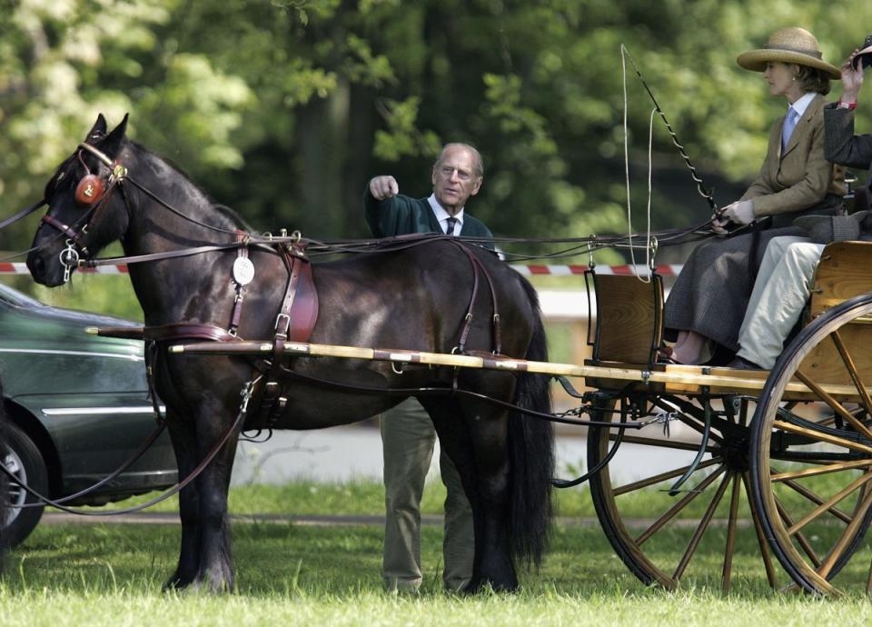 Prince Philip, Duke of Edinburgh points over Lady Penny Brabourne's horse before it competes in the Land Rover International Driving Grand Prix on May 11, 2006 (Getty Images)