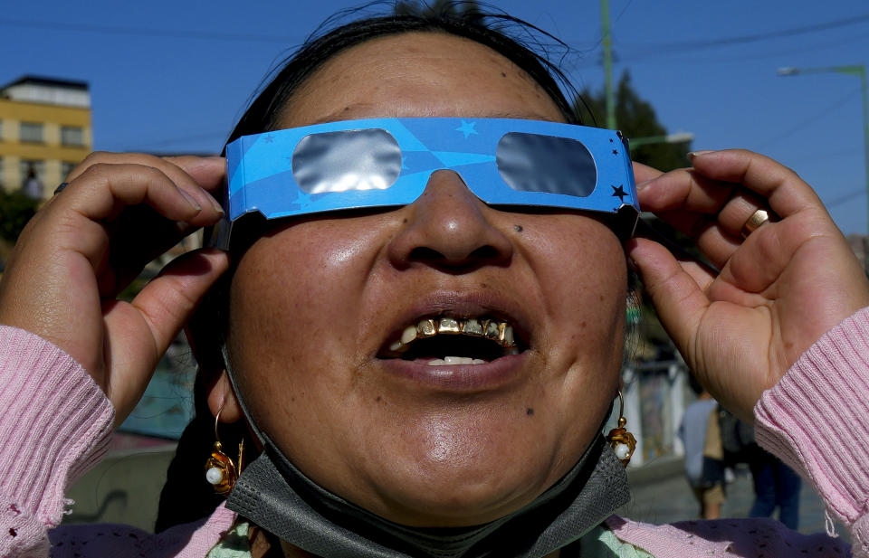 A woman watches the "ring of fire" solar eclipse in La Paz, Bolivia, Saturday, Oct. 14, 2023. The solar eclipse briefly dimmed the skies over parts of the western U.S. and Central and South America. (AP Photo/Juan Karita)