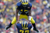 Denard Robinson #16 of the Michigan Wolverines celebrates a fourth quarter touchdown with Taylor Lewan #77 while playing the Nebraska Cornhuskers at Michigan Stadium on November 19, 2011 in Ann Arbor, Michigan. Michigan won the game 45-17. (Photo by Gregory Shamus/Getty Images)