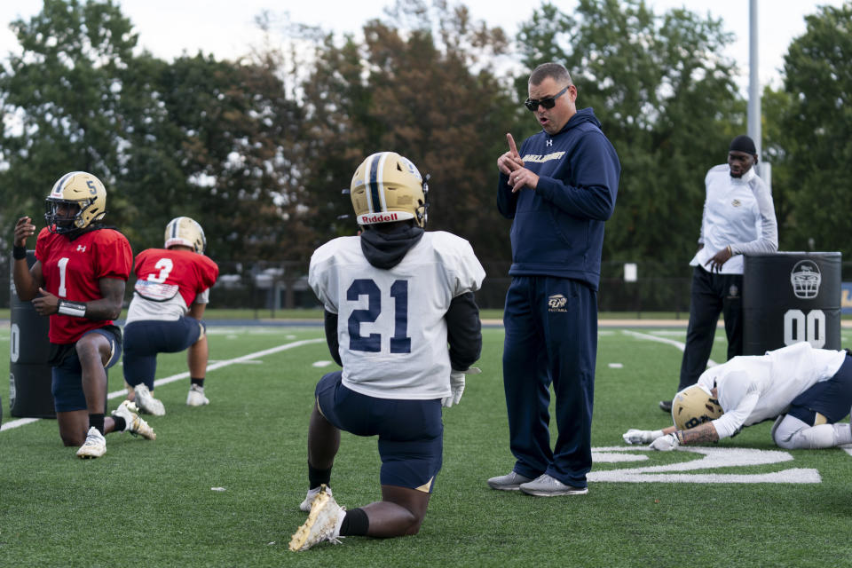 Gallaudet football head coach Chuck Goldstein, center right, talks with running back Joshua Kelley, left, using American Sign Language during football practice at Hotchkiss Field, Tuesday, Oct. 10, 2023, in Washington. (AP Photo/Stephanie Scarbrough)