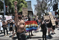 LGBTQ community members join Black Lives Matter protesters holding signs and chanting slogans on an intersection in West Hollywood, Calif. on Wednesday, June 3, 2020, over the death of George Floyd, a black man who washing detained by police in Minneapolis. Floyd died after being restrained by Minneapolis police officers on Memorial Day. (AP Photo/Richard Vogel)