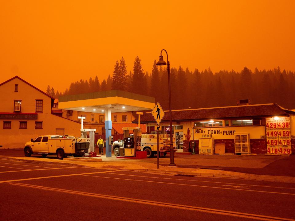 Emergency crews gas up against an orange sky.