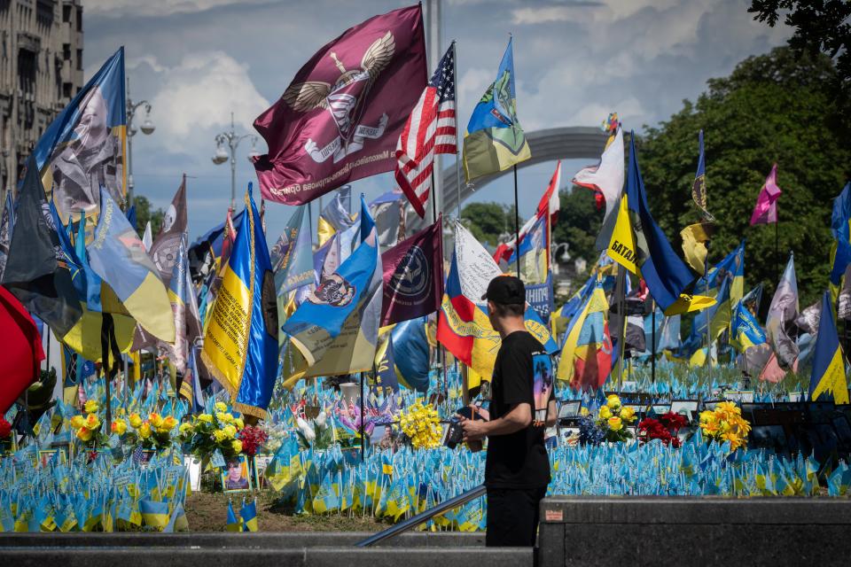 A passer-by looks at a makeshift memorial for fallen Ukrainian soldiers on Independence Square in Kyiv, Ukraine (AP)