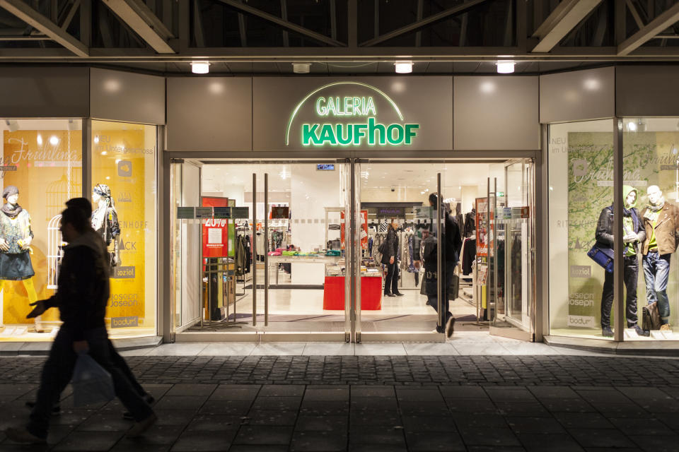 Wiesbaden, Germany - February 15, 2014: Illuminated entrance of Galeria Kaufhof in the city center of Wiesbaden. Galeria Kaufhof is a department store chain in Germany. It belongs to Metro AG, which is based in Duesseldorf, Germany. Some shoppers inside the store