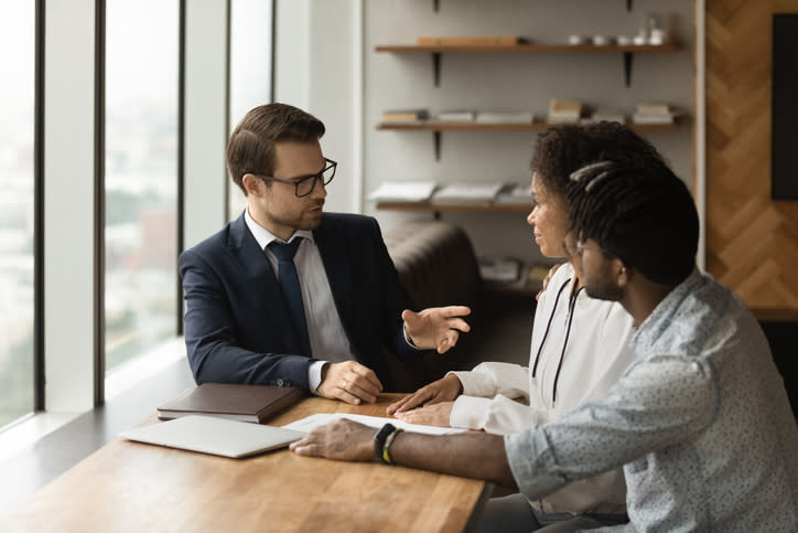 A financial advisor working with a couple on rebalancing their investment portfolio.