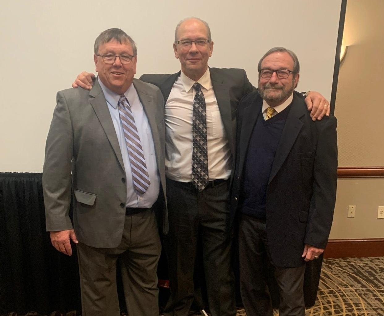 Former Battle Creek Central football coaches Doug Bess, left, and Dick Bush, right received the prestigious Jim Crowley Award at the annual Michigan High School Football Coaches Association Clinic. They were each presented the award by former BCC coach Al Slamer, middle.