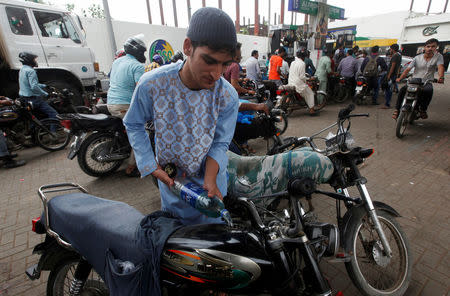 A customers fuels his motorcycle tank with petrol purchased from a station in Karachi, Pakistan July 26, 2017. REUTERS/Akhtar Soomro