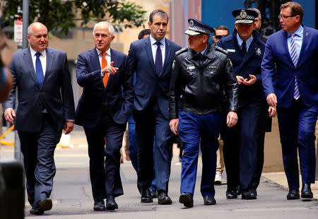 Australian Prime Minister Malcolm Turnbull walks with officials along a street before holding a media conference announcing Australia's national security plan to protect public places in central Sydney, Australia, August 20, 2017. REUTERS/David Gray