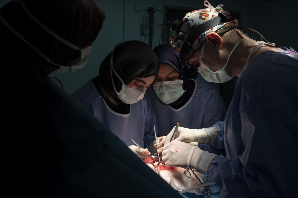 Dr. Vitaly Dedovich, right, of the Novick Cardiac Alliance medical team, performs open heart surgery at the Tajoura National Heart Center in Tripoli, Libya, on Feb. 26, 2020. (AP Photo/Felipe Dana)