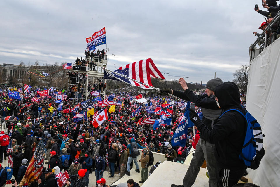 The man dubbed #SoggyKidInsider (in the foreground, holding the flag) at the Capitol on Jan. 6. (Photo: ROBERTO SCHMIDT / AFP via Getty Images)